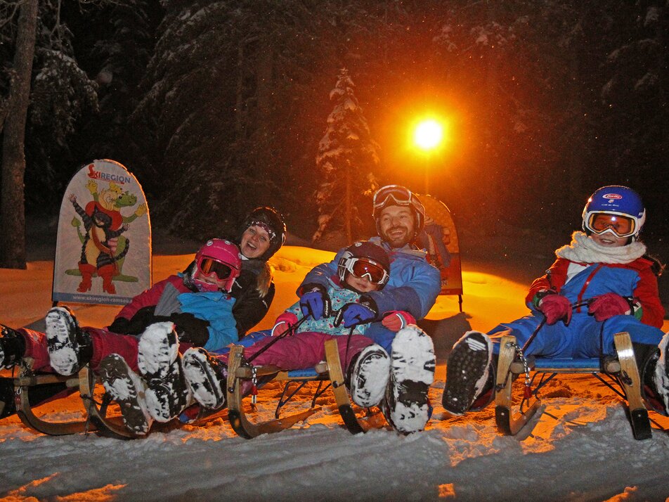 Familie auf Schlitten.  | © Hans-Peter Steiner