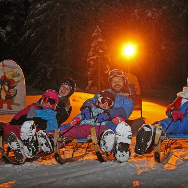 Familie auf Schlitten.  | © Hans-Peter Steiner