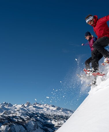 Schneeschuhwanderer springen in den Pulverschnee in Schladming-Dachstein | © Herbert Raffalt