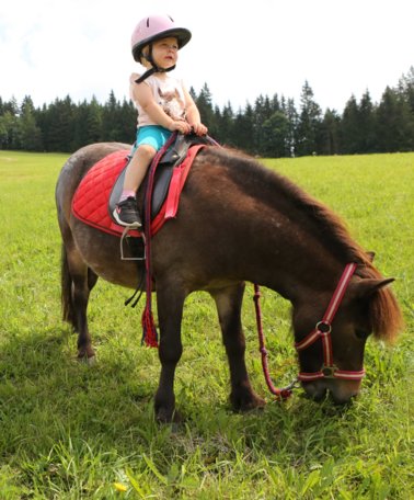 Zwei kleine Mädchen beim Ponyreiten