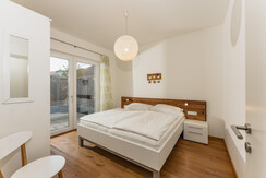 Schlafzimmer mit Doppelbett und Terrassenzugang
